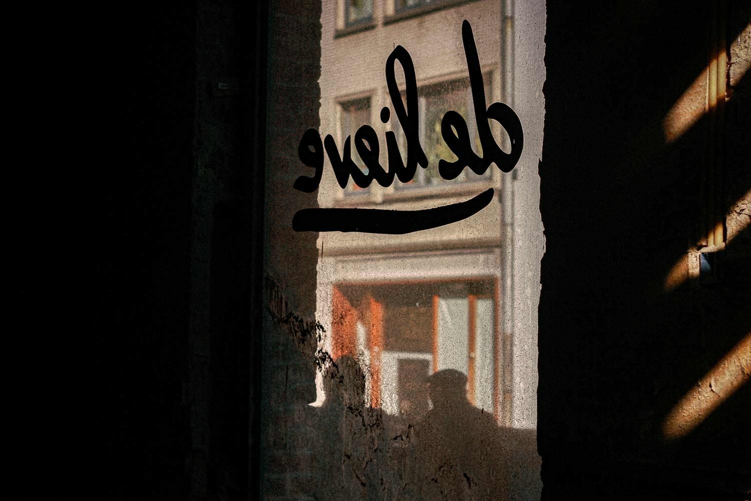 Oude logo van De Lieve op een raam in Gent