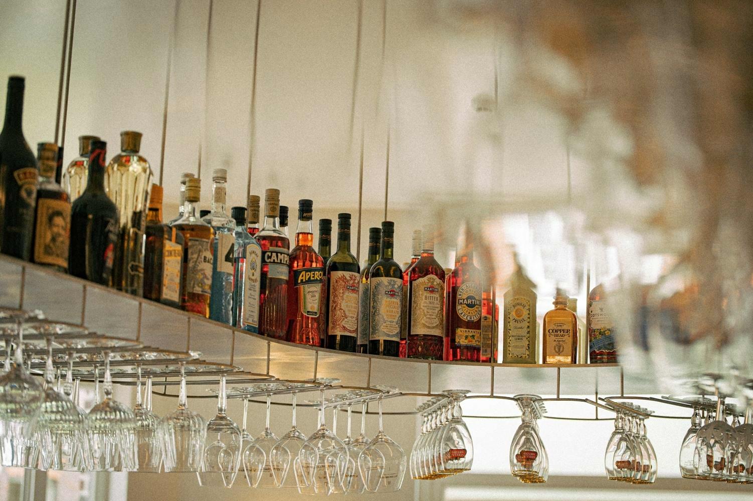 Verschillende flessen sterke drank in de bar van De Lieve